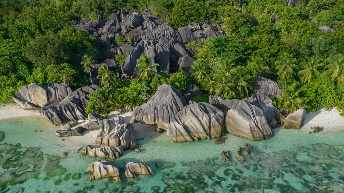 The granite boulders and shallow water that mark the Seychelles coastline