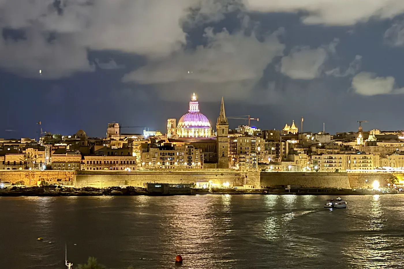 Valletta lit up at night, seen from Sliema across the harbour