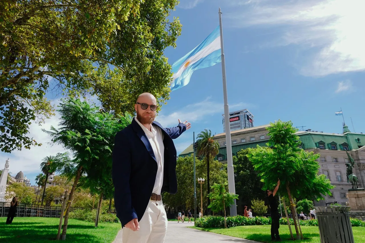 David Lincoln beside the Argentine flag in a Buenos Aires plaza