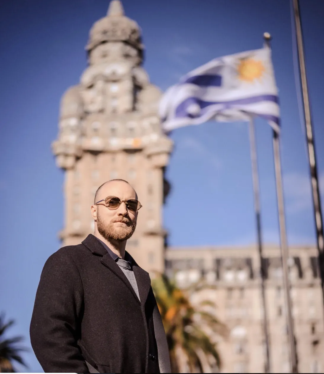David Lincoln in front of the Palacio Salvo and the Uruguayan flag in Montevideo