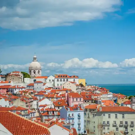 Terracotta rooftops of Alfama with the Tagus beyond