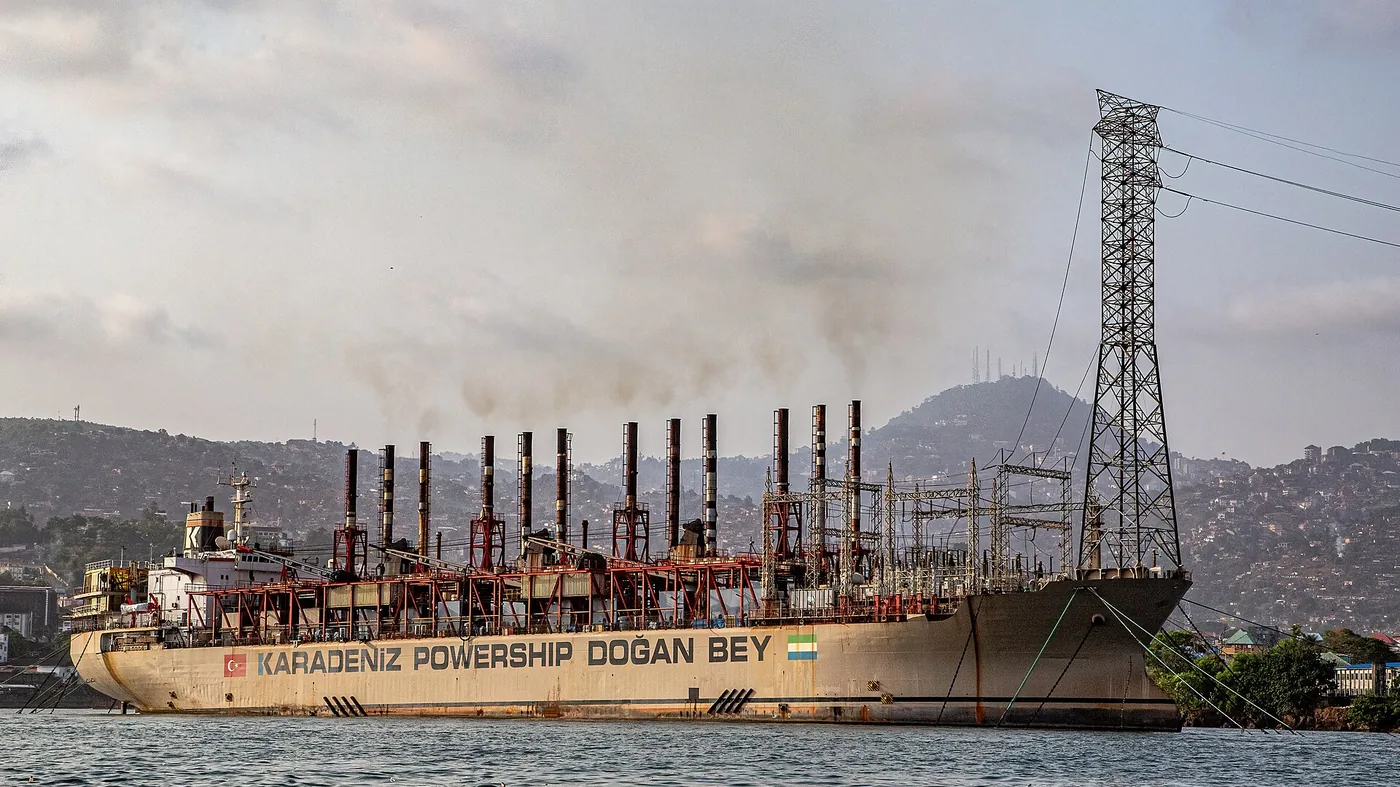 A Karpowership floating power plant moored off Freetown, with the hillside city behind it