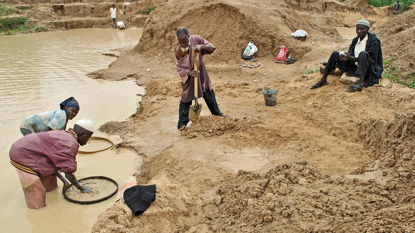 Artisanal miners panning and digging at an alluvial working in Sierra Leone
