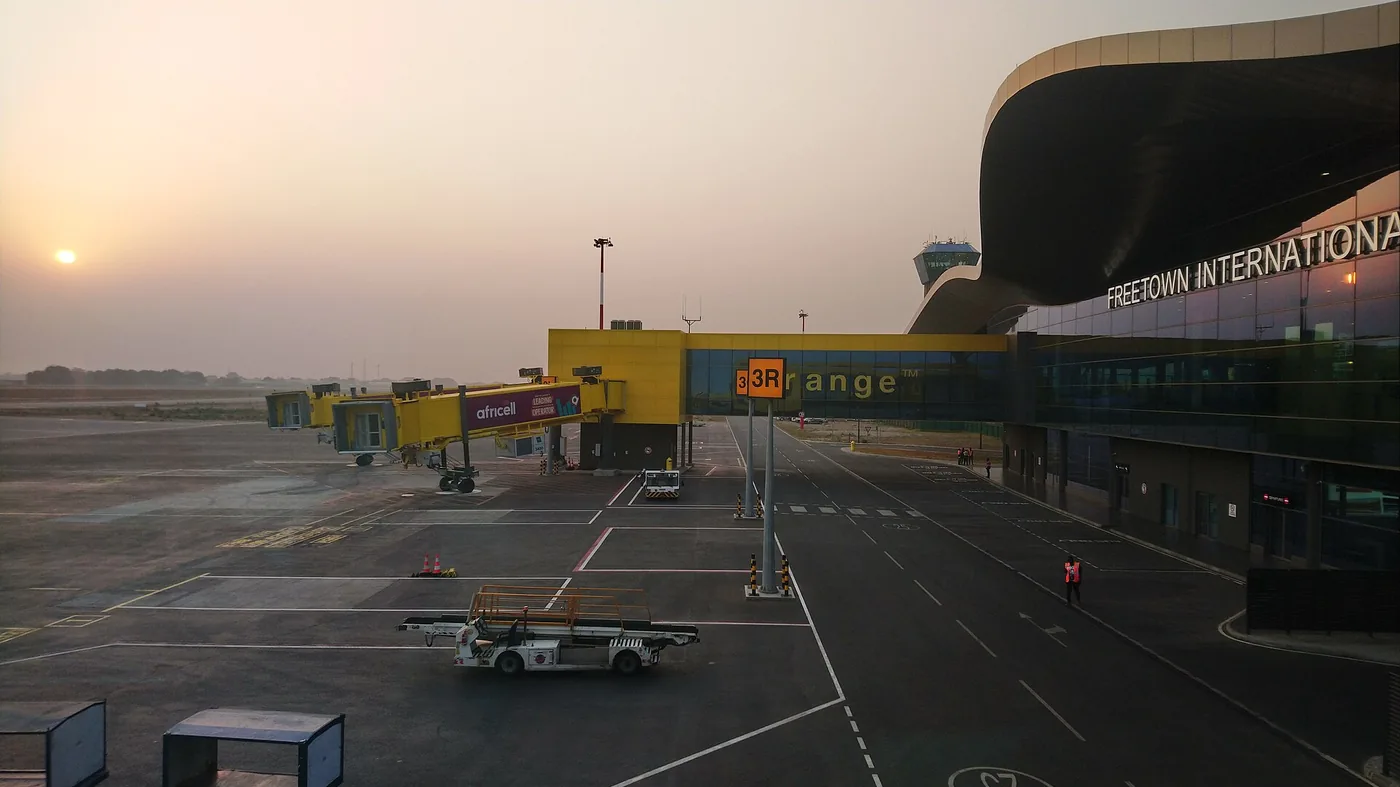 The terminal at Freetown International Airport at dawn, with boarding bridges at the gates