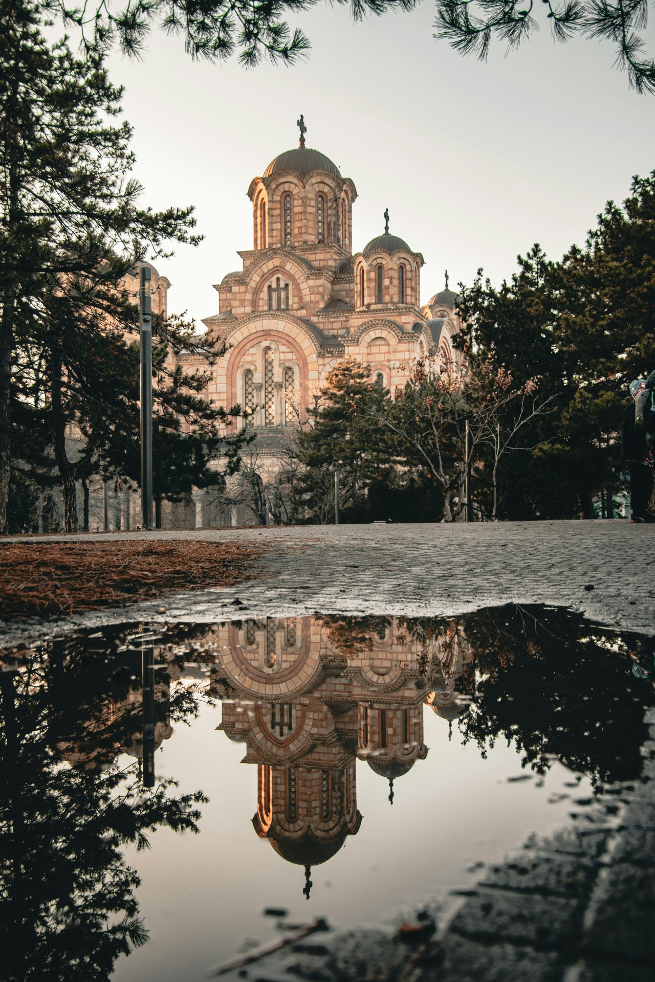 St Mark's Church in Belgrade at dusk, reflected in a puddle on the cobbles